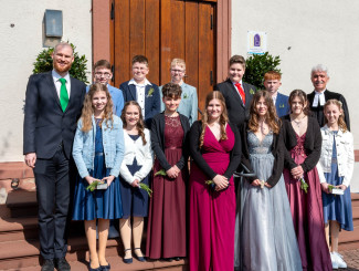 Nach dem Festgottesdienst stellten sich die Konfirmierten zum Gruppenbild: Eingerahmt von Jugendreferent Björn Pahl und Pfarrer Bernd Töpfer: (vorne v.li.) Sophie Freudenberger, Ronja Zeuch, Celine Schäfer, Hannah Kern, Zoey Peterson, Samantha Peterson, Lina Bröstler, (hinten v.li.) Finn Semmler, Anton Gräder, Fabian Betz, Maximilian Freudenberger, Leon Götz 